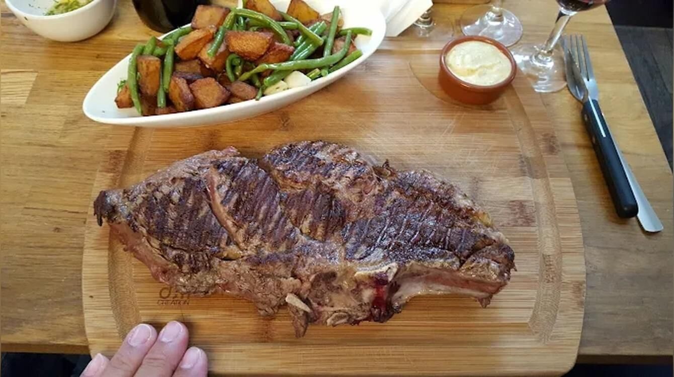Pièce de bœuf grillée sur planche, pommes sautées et haricots verts