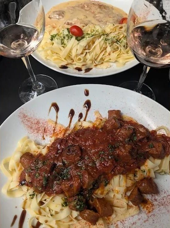 Tagliatelles en sauce et verres de vin rosé